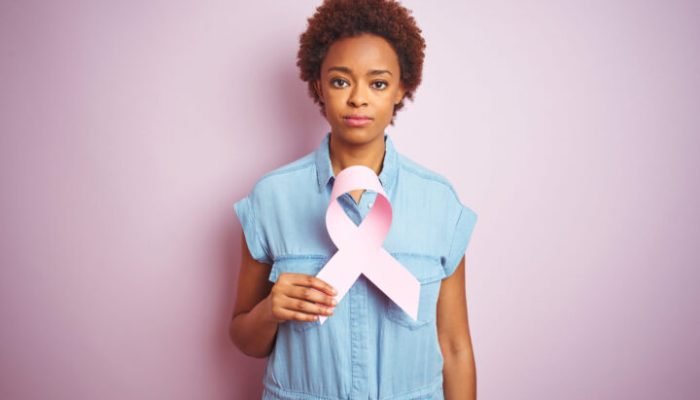 Young,African,American,Woman,Holding,Brest,Cancer,Ribbon,Over,Isolated